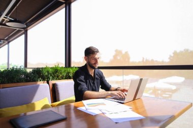 Başarılı foreman kafede dizüstü ve belgeleri kullanma.