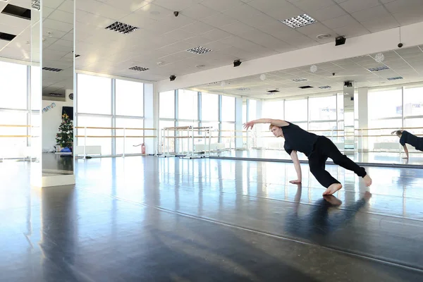 Homme sportif au studio de danse tenant les jambes écartées — Photo