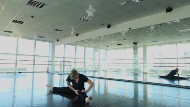 Male person sitting on twine and doing stretching — Stock Video