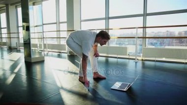 Erkek kişi laptop vasıl jimnastik salonu ile yeni hareketleri öğrenme