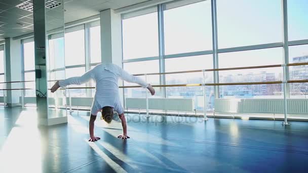 Guy handstand maken met benen verspreid op gym studio — Stockvideo
