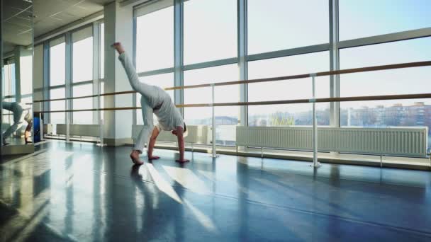 Oerfaren i sport affärsman i sportkläder försöker stå på händer i gymmet — Stockvideo