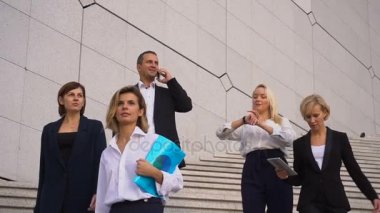 Mali takım yavaş tablet, dava ve smartphone ile konuşurken merdivenlerden aşağı gidiyor.