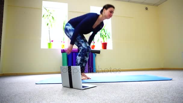 Businesswoman studies basic yoga exercises on online course. — Stock Video