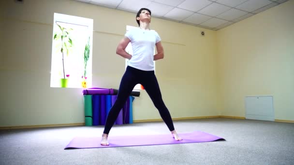 Красивая молодая женщина с темными волосами выполняет упражнения йоги . — стоковое видео