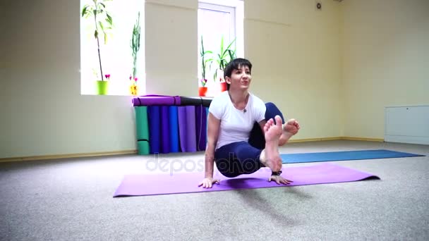 Kvinna med europeiskt utseende bedriver yoga i fitnesstudion. — Stockvideo