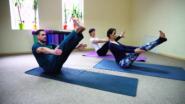 Drei junge Leute machen Yoga im Fitnessstudio. — Stockvideo