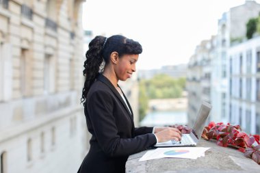 Yarım Afrika işkadını balkonda laptop ile çalışma.