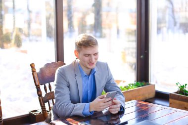 Yanında smartphone tablet yakınındaki kafede chat yapan işadamı.