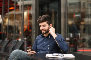 Amerikalı çocuk Café earphones ve akıllı ile müzik dinlemek