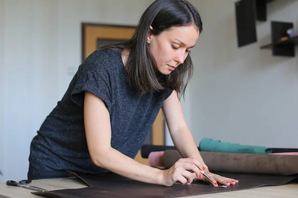 Fille en utilisant le congé de maternité pour faire des accessoires en cuir . — Photo