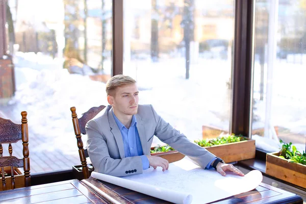 Student of architecture faculty looking at drafting work at cafe