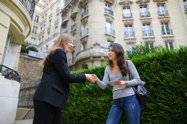 Beautiful girl talking with foreign Chinese student keeping tabl