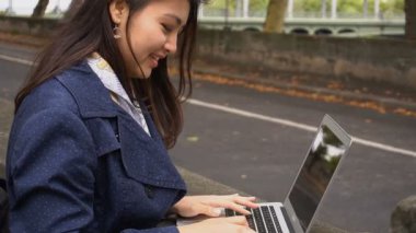 Çinli kız dışında dizüstü eller yakından ile ağır çekimde yazmaya.