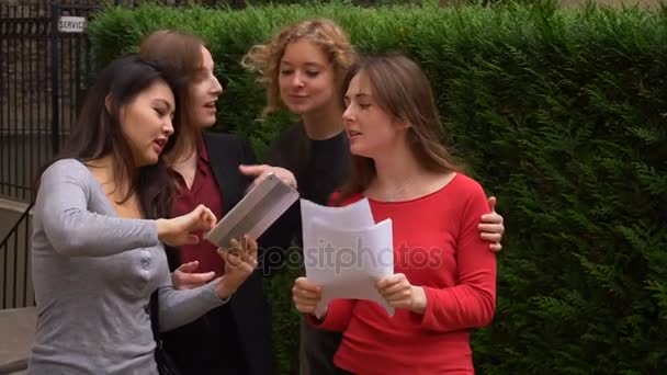 Студенты наслаждаются с табличкой возле здания университета и изучают английский язык с документами в замедленном режиме . — стоковое видео