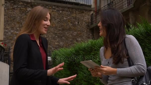 Vacker flicka talar med utländska kinesisk student hålla tablett i slow motion och skaka hand. — Stockvideo