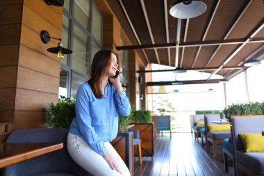 Güzel kadın modeli smartphone tarafından fotoğrafçı ile konuşma