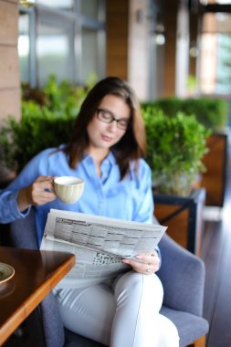 Restoran koltuk oturma ve newspape okuma güzel kız