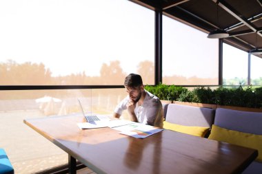 Beyaz işadamı laptop ve belgeleri masada çalışma
