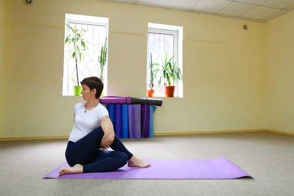 Frau mit europäischem Aussehen beim Yoga im Fitnessstudio. — Stockfoto