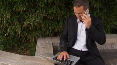 Smartphone ile konuşmak ve yavaş hareket dışında laptop ile çalışma Yöneticisi.
