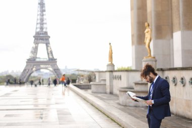 Melez pressman gazete makalesi Eiffel Tower yakınındaki okuma.