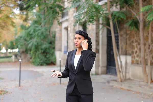 Negro persona femenina charlando en el teléfono inteligente fuera . — Foto de Stock