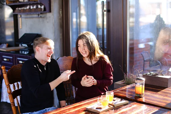 Couple sitting near table with sea-buckthorn broth in cafe discu — Stock Photo, Image