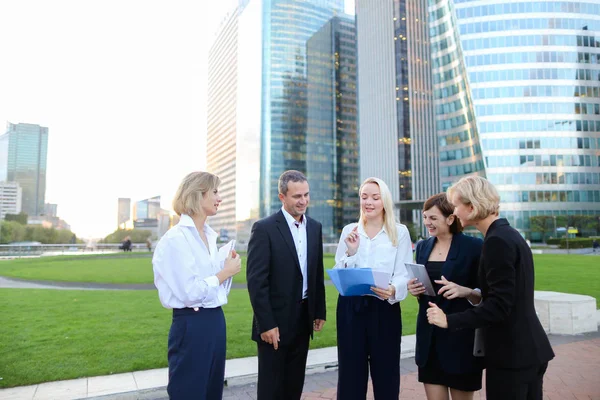 Employees of large corporation going with document case, laptop