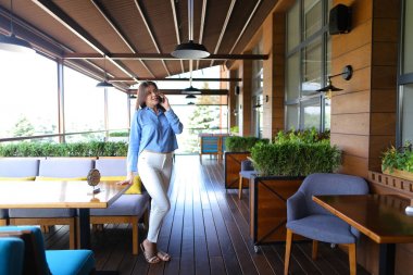 Güzel kadın modeli smartphone tarafından fotoğrafçı ile konuşma