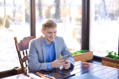 Yanında smartphone tablet yakınındaki kafede chat yapan işadamı.