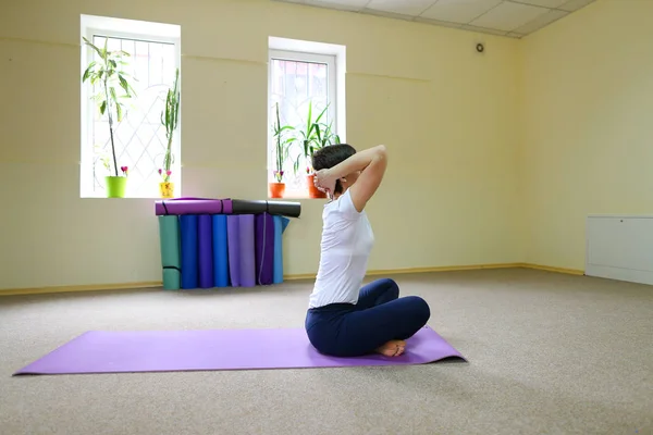 Jovem mulher de aparência americana realiza asanas de ioga . — Fotografia de Stock