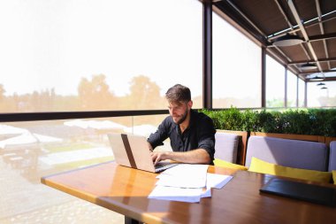 Miktar arazi kafeterya masada kağıtları ve dizüstü bilgisayar ile çalışma.