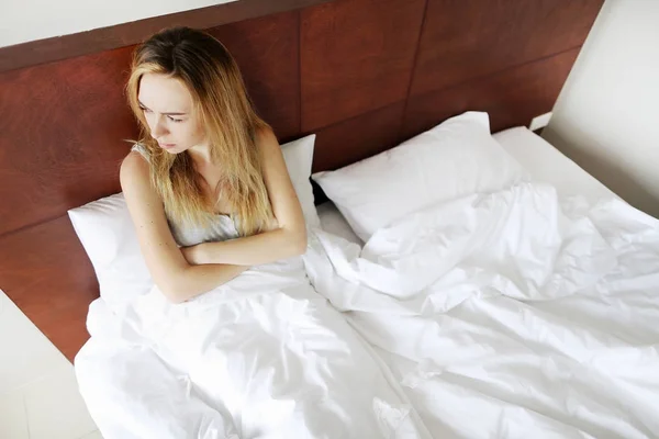 Женщина obuse лежа в белой кровати — стоковое фото
