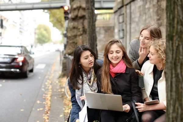Kvinnliga studenter som sitter på bänken och lärande med laptop och pa — Stockfoto