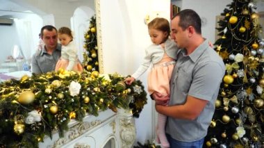 Mutlu baba ve zarif Noel ağacı oturma odasında arka plan üzerinde konuda şenlikli süslemeleri ile şirin kız.