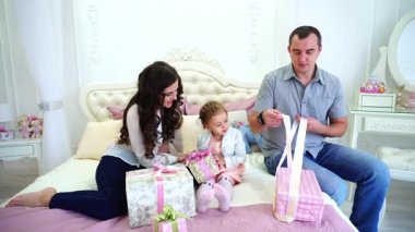 Güzel anne ve kızı şenlikli duygudurum sorunları ve hediyeler Oda şenlikli Noel ağacı arka plan üzerinde oturan yakınları için hazırlamak.