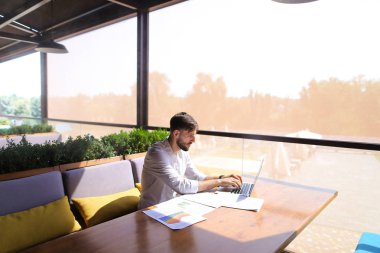 Amerikalı yatırımcı laptop ve diyagram belgelerle çalışma