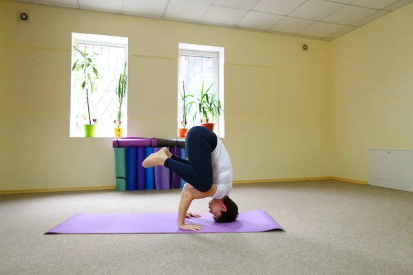 Bella giovane donna con i capelli scuri esegue esercizi di yoga . — Foto Stock