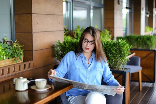 레스토랑에서 신문 읽기와 차를 마시는 매력적인 여자 — 스톡 사진