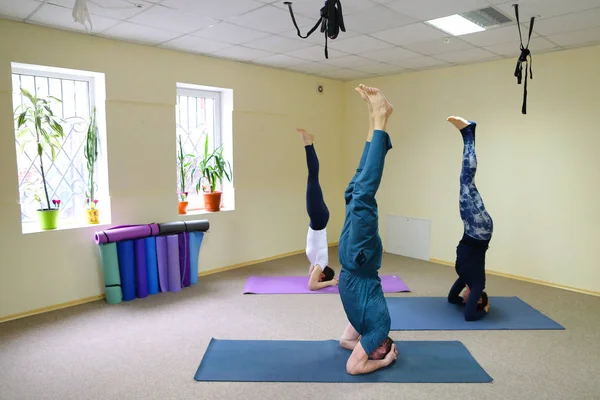 Tre giovani che fanno yoga in palestra . — Foto Stock