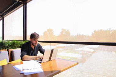 Miktar arazi kafeterya masada kağıtları ve dizüstü bilgisayar ile çalışma.