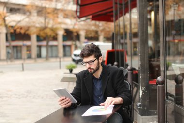 Diyagram ve tablet çalışma istatistikçi kafeterya masada .