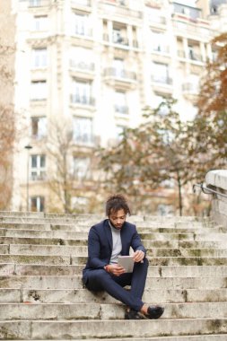 Yakışıklı yarım Nijeryalı adam adımları tablete tarafından kızla sohbet