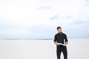 Deniz kenarında çizimler ile ilgilenen ressam erkek.