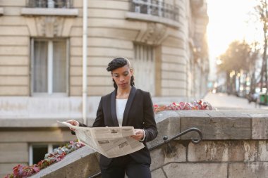 Yarım Nijeryalı muhabir cam balkon gazete ile seyir.