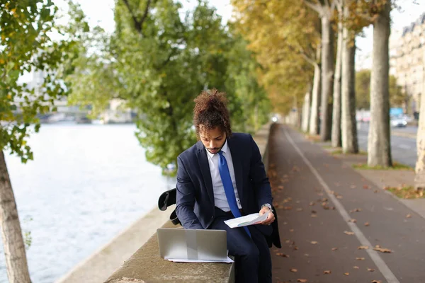 Hispanic professor in detached duty working with laptop.