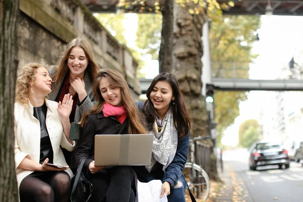 Kvinnliga studenter som sitter på bänken och lärande med laptop och pa — Stockfoto