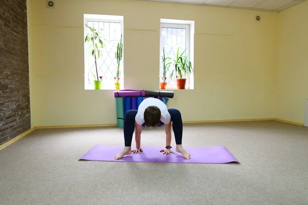 Joven mujer de aspecto americano realiza asanas de yoga . —  Fotos de Stock