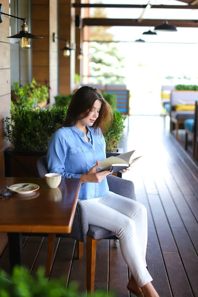 Hermosa chica leyendo diario en la cafetería   . — Foto de Stock
